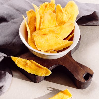 Bright and tasty homemade mango chips in a bowl, perfect for a healthy snack.