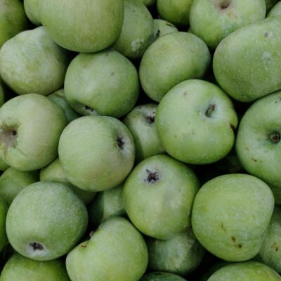 Close-up of numerous fresh green apples creating a vibrant background.