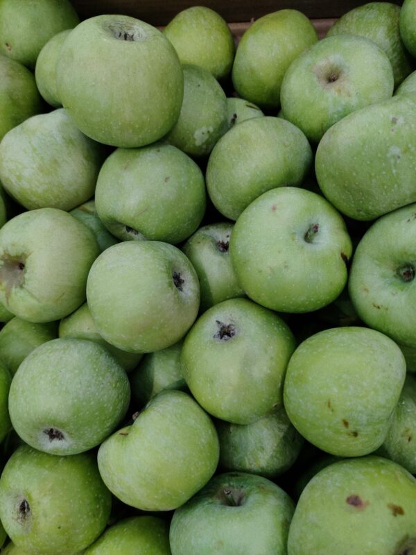 Close-up of numerous fresh green apples creating a vibrant background.