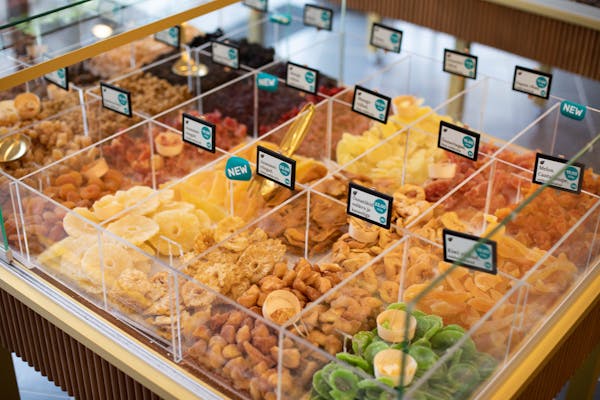Vibrant assortment of dried fruits in a retail display, offering various flavors.