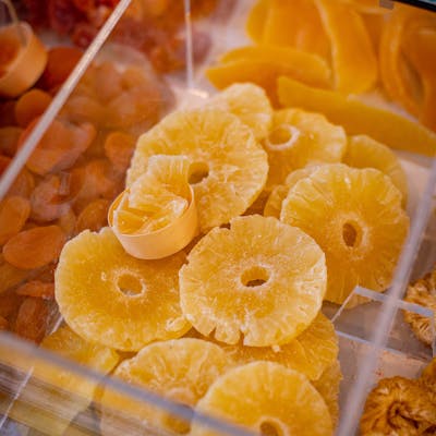 Vibrant dried pineapple rings displayed in a market setting. Ideal for culinary and travel stock imagery.