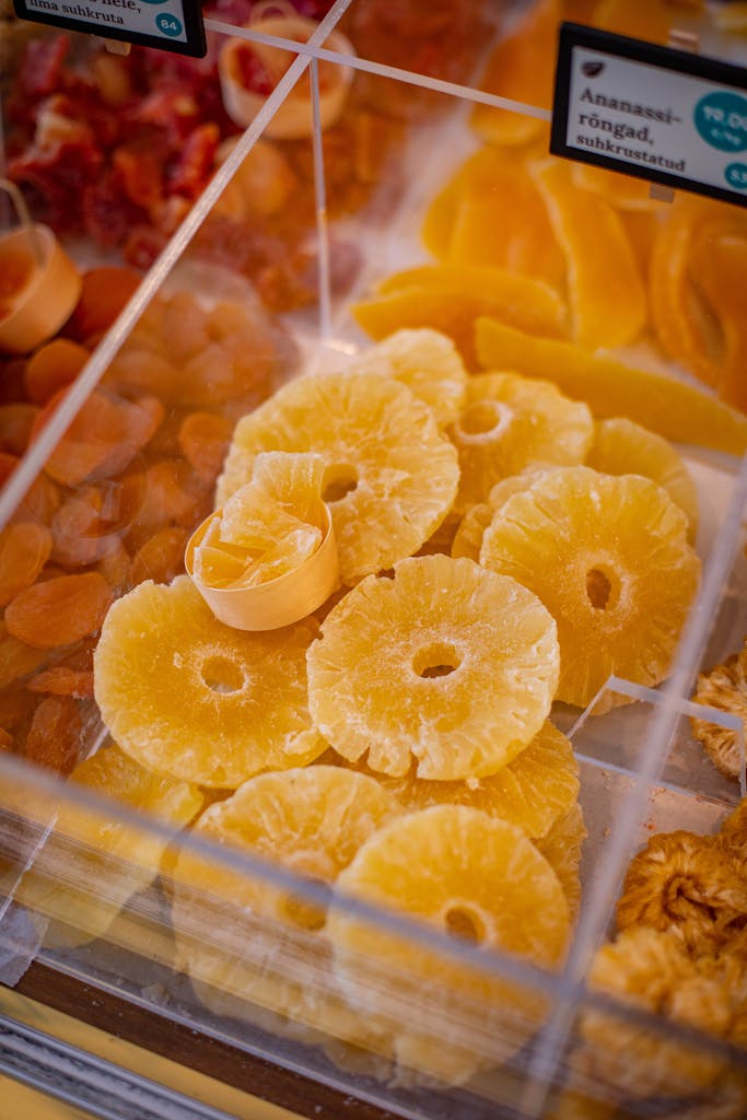 Vibrant dried pineapple rings displayed in a market setting. Ideal for culinary and travel stock imagery.